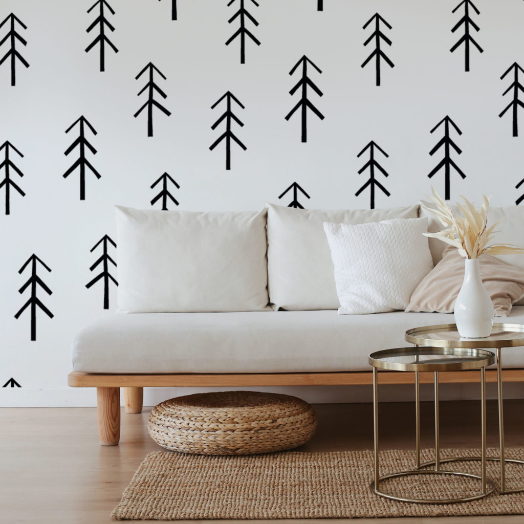 bold black and white wallpaper with minimal abstract trees in front of white couch