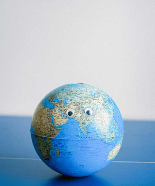 A globe with googly eyes, representing sharing and showcasing creative work with the world and prospects.